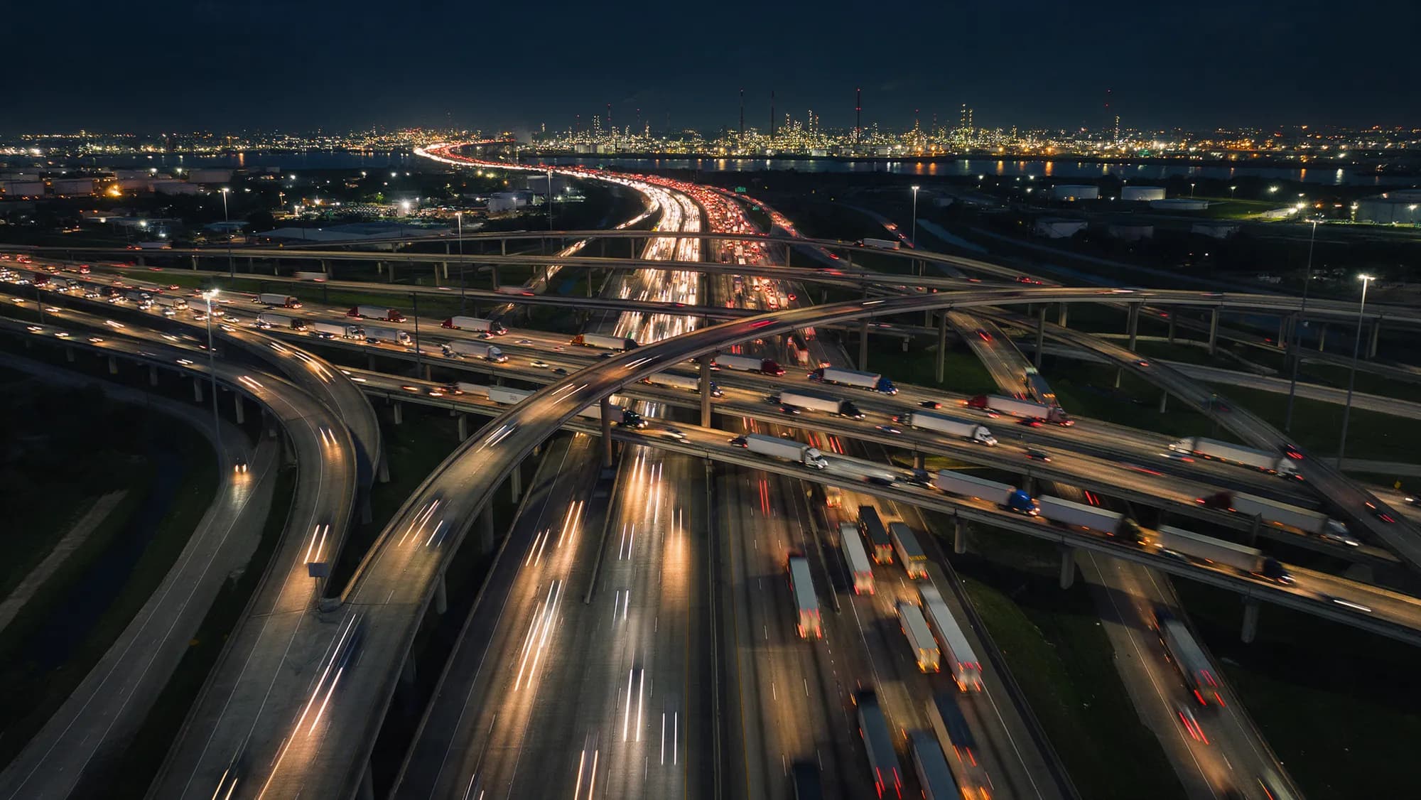 A Houston freeway interchange at dusk crowded with 18-wheelers